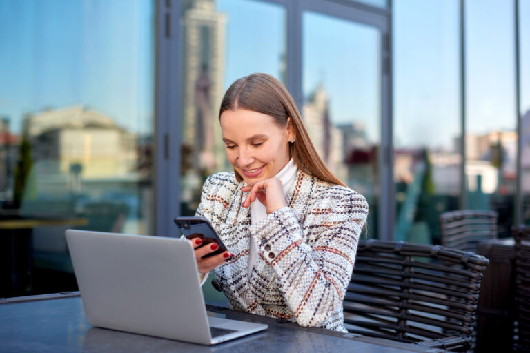 self employed business woman working remote on laptop in city cafe