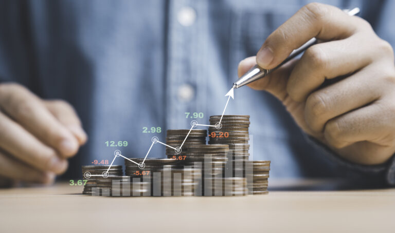 Businessman drawing increasing graph with coin stacking for incr