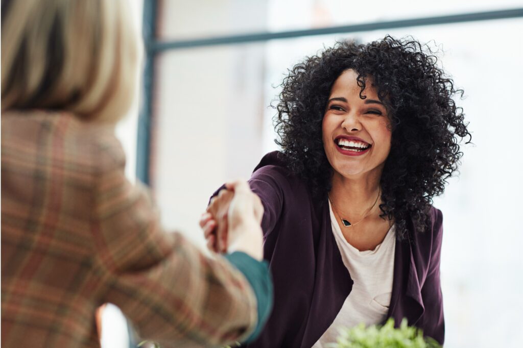 woman shaking hands across table