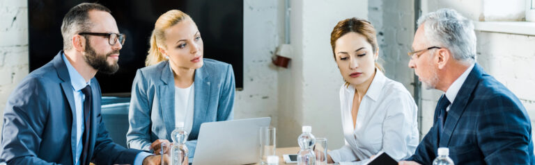 Image of business executives having a conversation around a table.