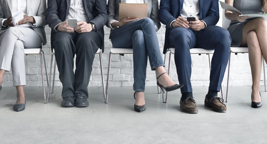 Image of job candidates sitting in a horizontal line.