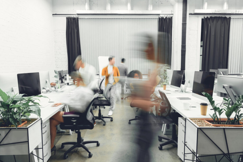 Business professionals working in a fast-paced office environment, illustrating operational performance and organizational complexity.