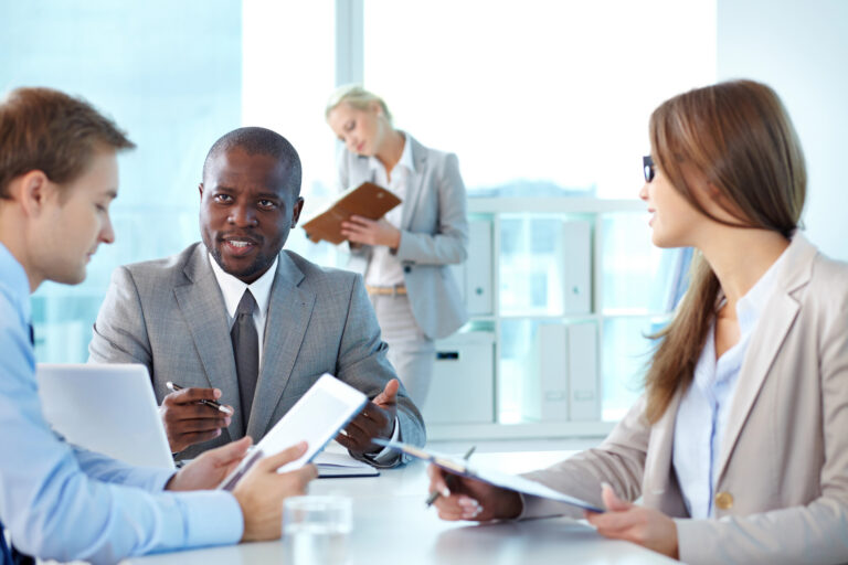 Business professionals discussing recruitment process outsourcing strategies to improve hiring efficiency and reduce recruiting costs.