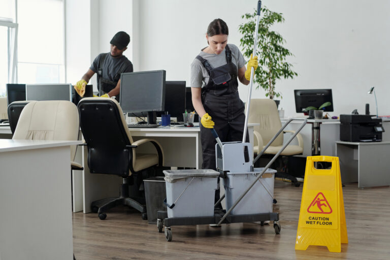Professional janitorial staff cleaning and maintaining a modern office workspace, demonstrating commercial cleaning services and workplace facility management.