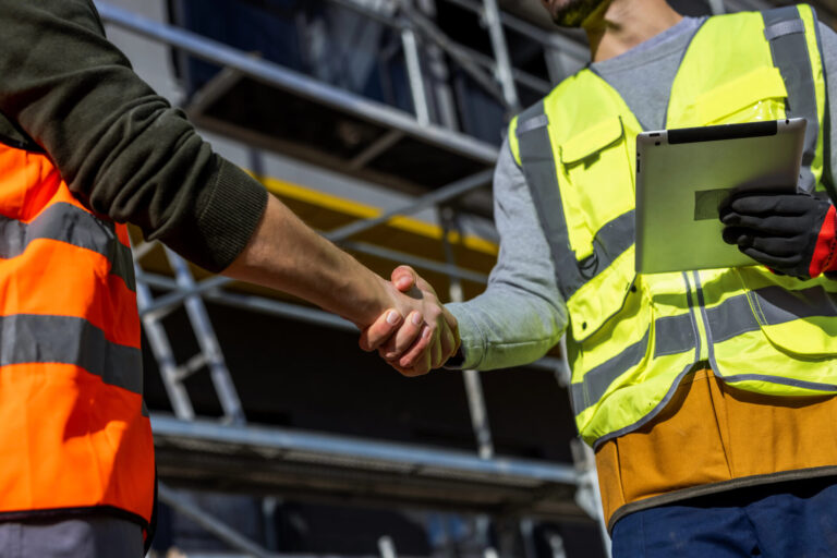 Manufacturing workers and workforce partner discussing hiring and recruiting operations at an industrial facility.