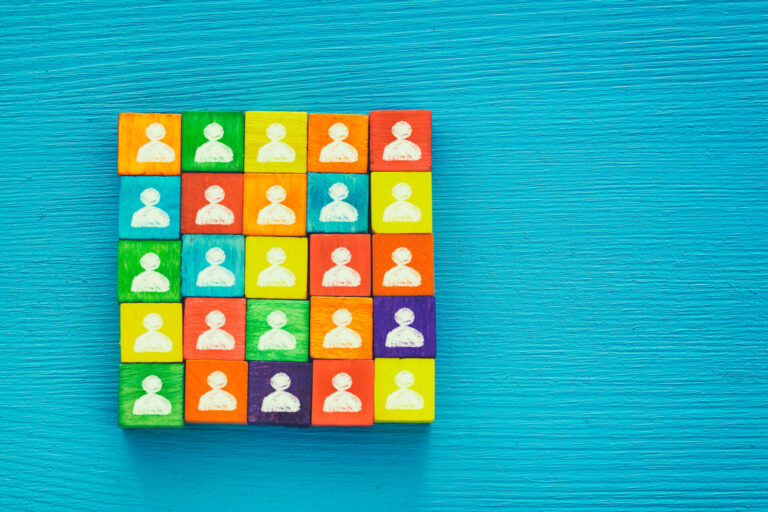 Colorful wooden blocks with people icons arranged in a grid on a turquoise background.
