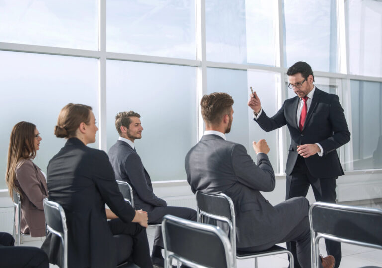 Business professional leading a group discussion in an office, illustrating high-volume recruiting.