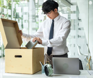 Young professional packing up his desk after resigning from his job
