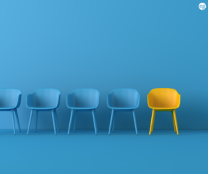 blue background with blue chairs in a row but one chair is yellow