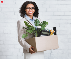 BIPOC Woman Smiling Holding a Box of Office Items