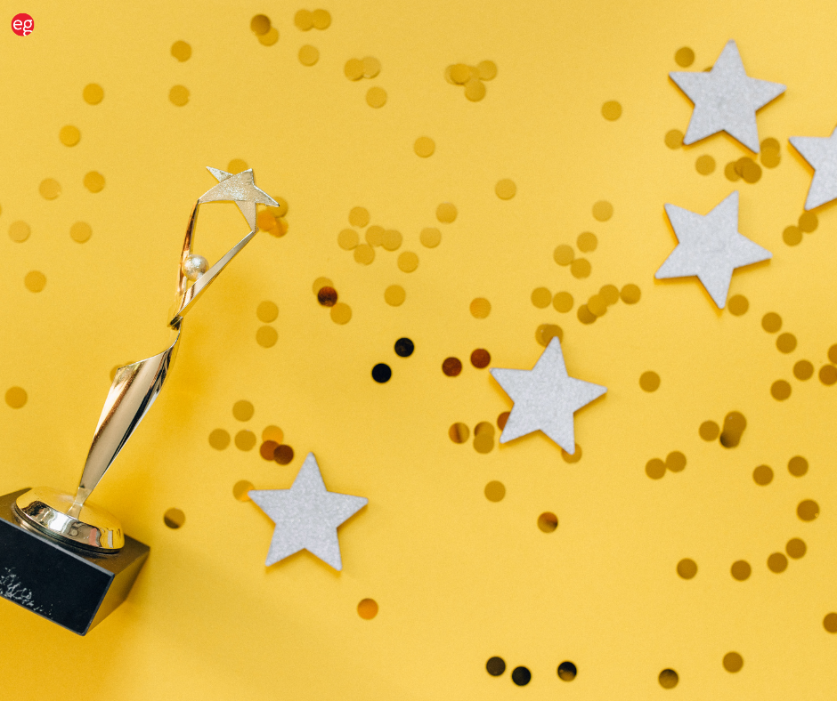 Confetti and stars and trophy on a yellow background