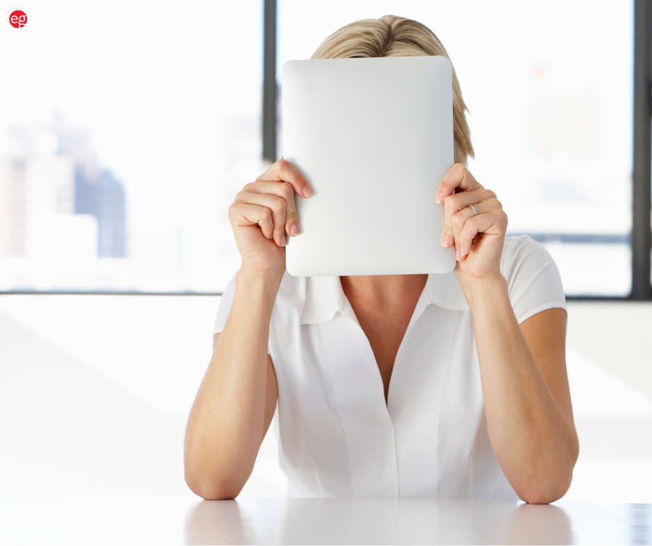 Woman hiding her face with a blank sheet of paper