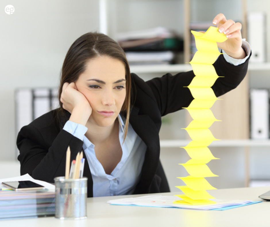 Woman looking board at a desk playing with sticky notes