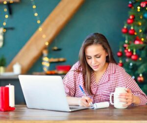 Woman in festive holiday dress working on a laptop
