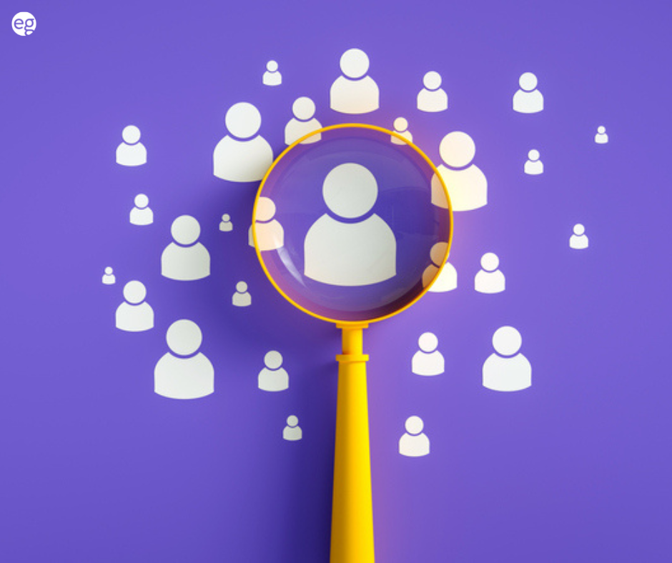 Yellow magnifying glass looking at people on a purple background