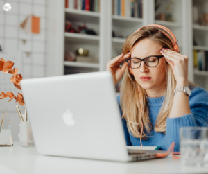 Woman looking stressed in front of a laptop