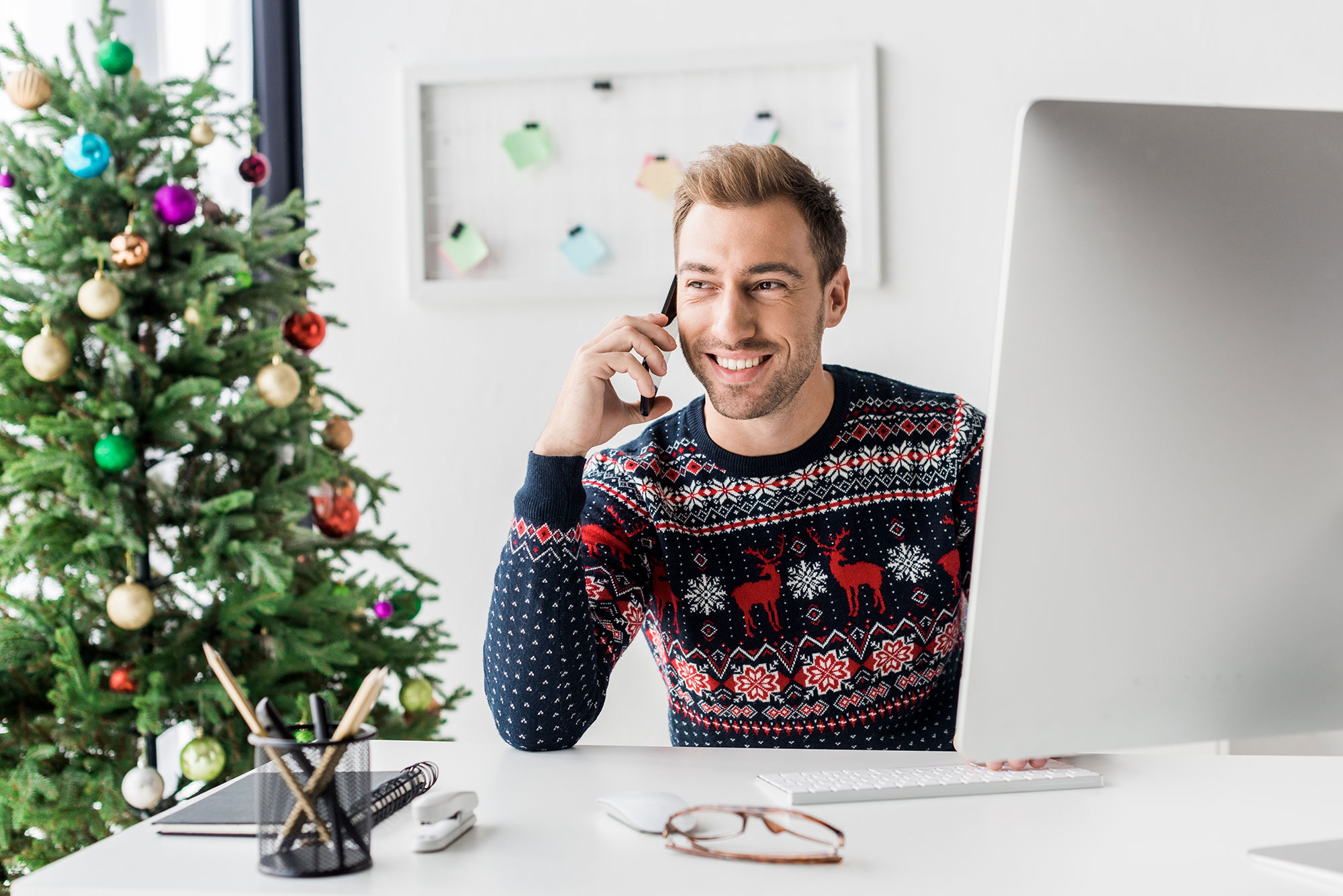 Man in holiday sweater working