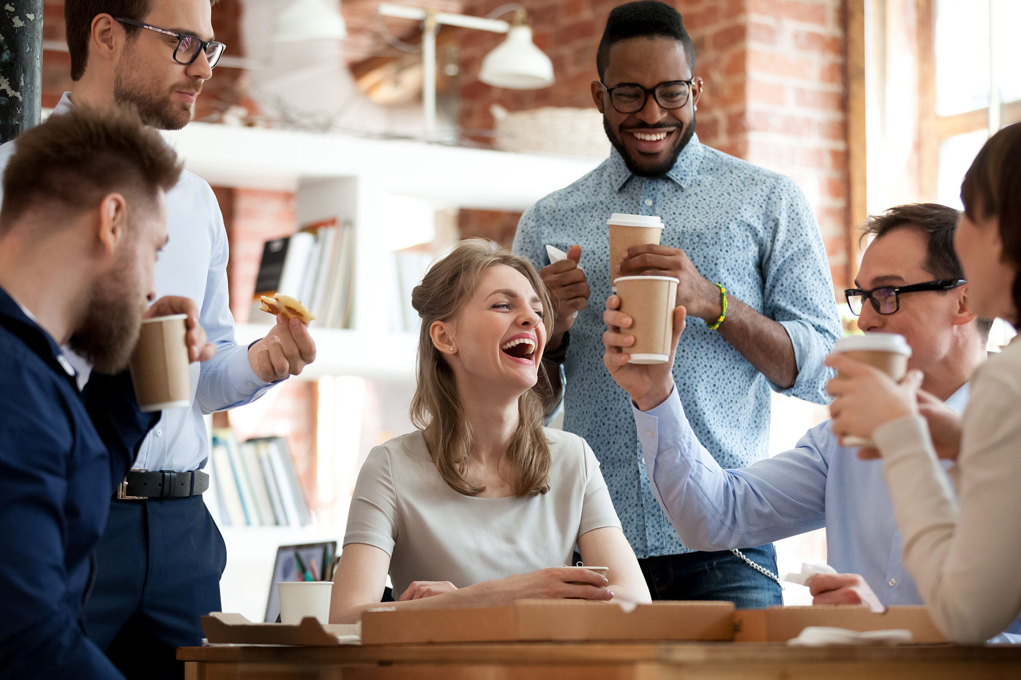 Happy diverse colleagues celebrate during a break in office